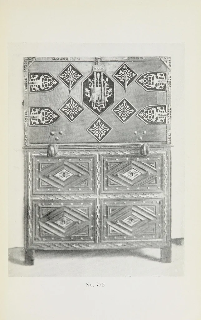 An illustration from Catalogue of the highly interesting and valuable collection of authentic Spanish antiques formed by Señor Luis Ruiz... : silver cathedral lanterns of the XVII century, the very rare carpets of the XVI & XVII century, the primitive paintings with their Gothic frames, also the wood and stone carvings, the Barguenos, cabinets, chests and chairs, the iron work and the old laces and fabrics, 1921, leaf 73