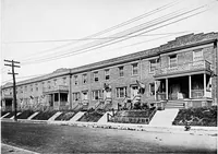 An illustration from The housing book; containing photographic reproductions, with floor plans of workingmen's homes. One and two family houses of frame, brick, stucco and concrete construction; also four, six and nine family apartments. Showing single houses, groups and developments that have been built in various parts of the United States (1919)